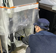 스탠드형 에어컨 내부를 세척하는 작업자
